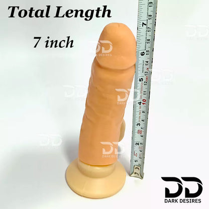 An adult novelty product shaped like a realistic penis, shown standing upright on a round base next to a metal ruler for scale, with text reading 'Total Length 7 inch' A realistic skin-toned dildo with a black harness-style base Black faux leather harness with an adjustable strap and a skin tone realistic dildo protruding from the front, displayed 7 inch realistic strapon dildo with adjustable harness kit for  for pegging . Lifelike veins, sculpted balls, skin tone, soft glans.  Black faux leather belt Sex 